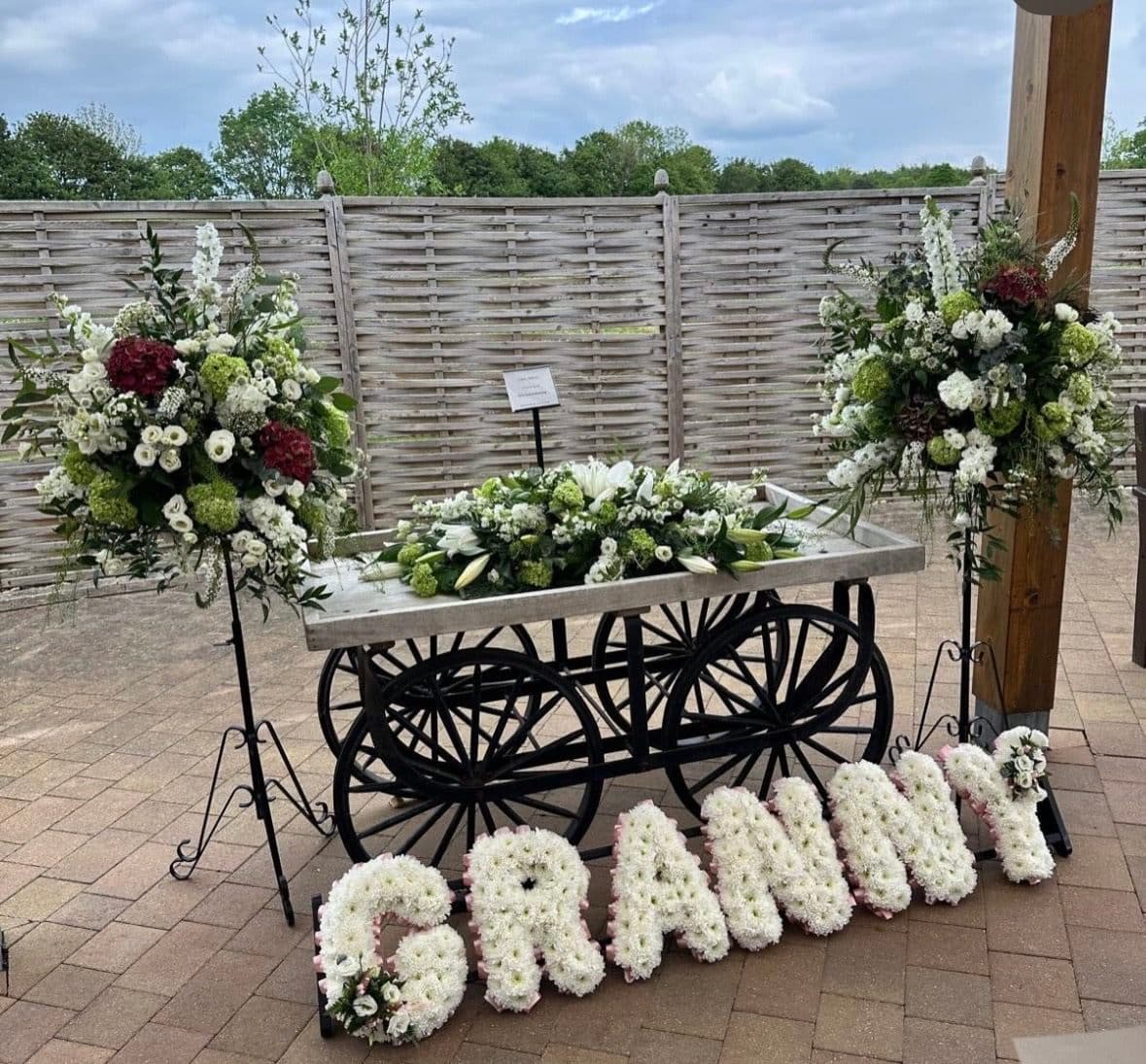 Floral tributes with white lettering and sympathy arrangements prepared for a farewell